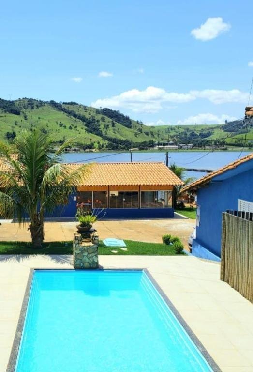 Piscina, a casa azul de telhado cerâmico e o lago ao fundo